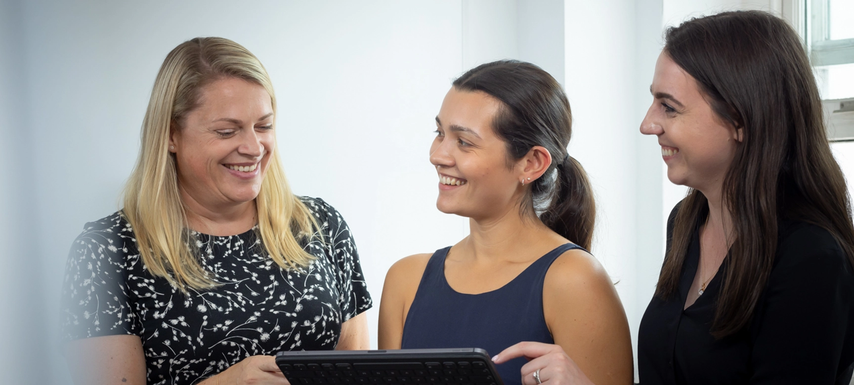 Three Women Employees Looking At Tablet