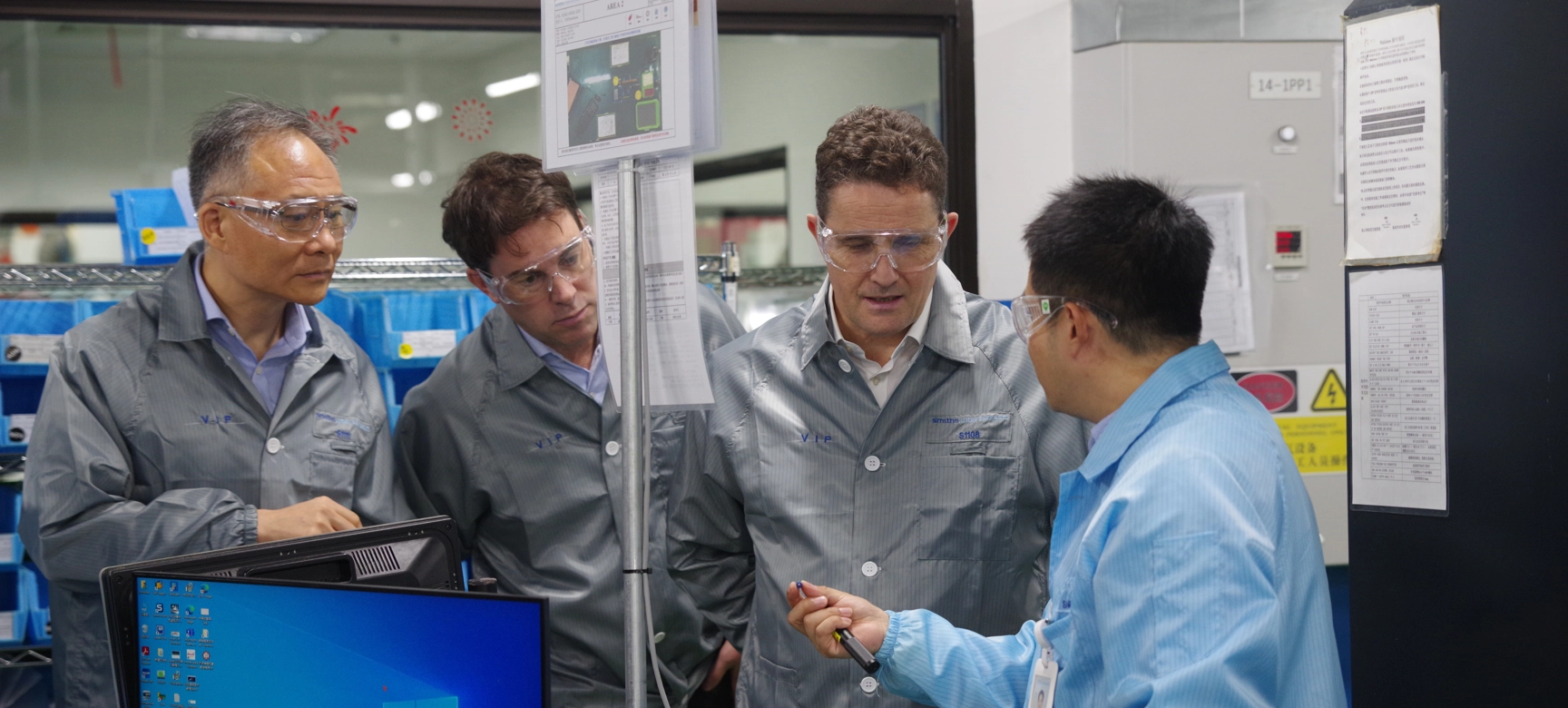 Four People Looking At Tool